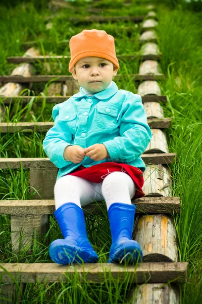 Niño sentado en una escalera en el parque — Foto de Stock