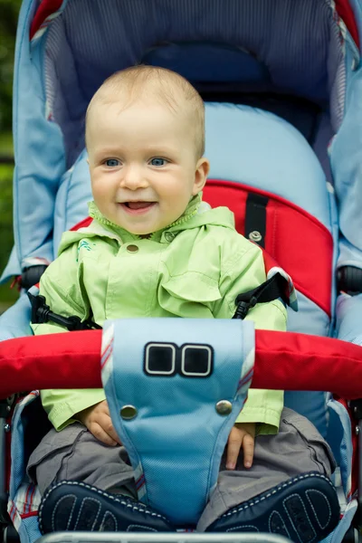 Beautiful child sitting in baby carriage — Stock Photo, Image
