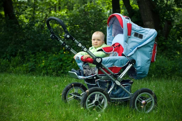 Linda criança sentada em carrinho de bebê — Fotografia de Stock