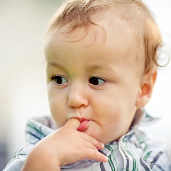 Niño sostiene el dedo en la boca —  Fotos de Stock