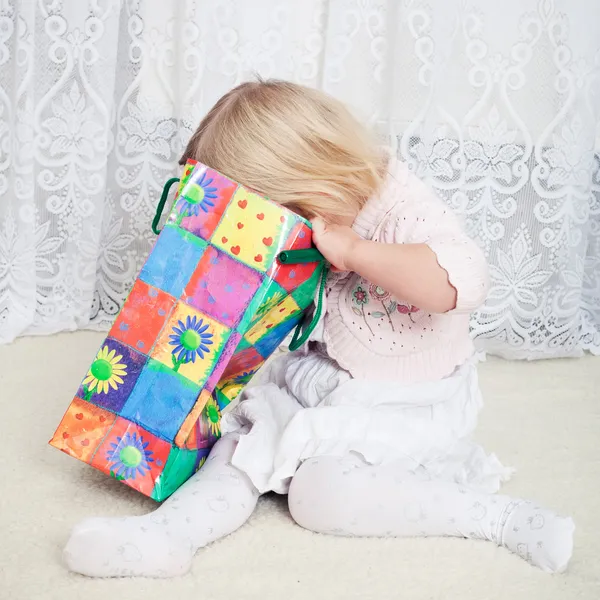 Little girl looks in the shopping bag — Stock Photo, Image