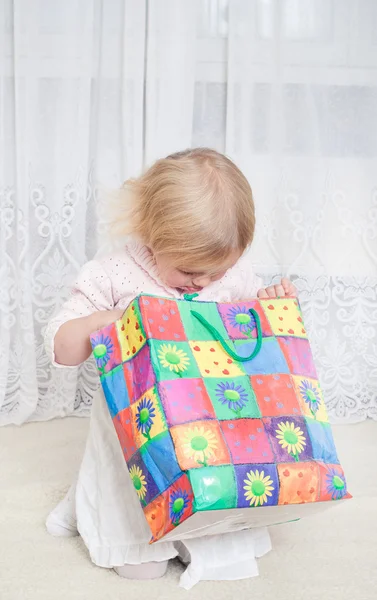 Petite fille regarde dans le sac à provisions — Photo