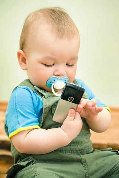 Младенец играет с мобильным телефоном — стоковое фото