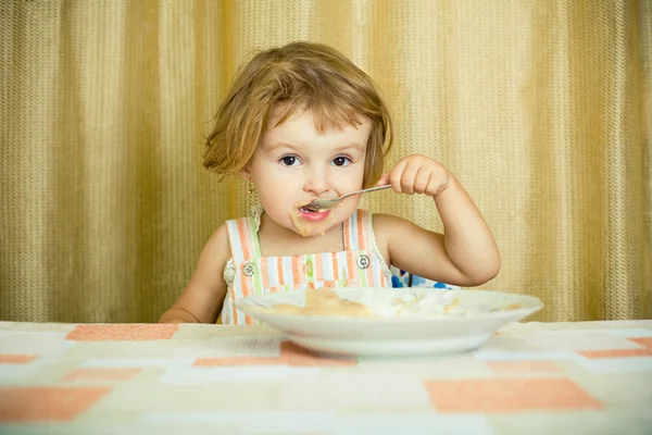 Little girl eats porridge — Stock Photo, Image