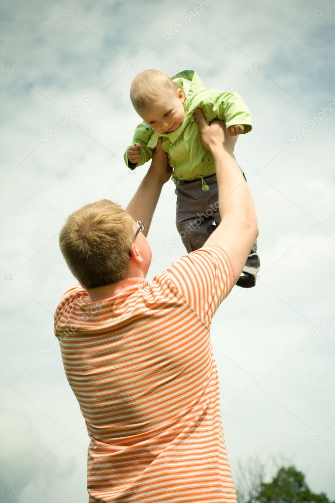 Father holds son in hands