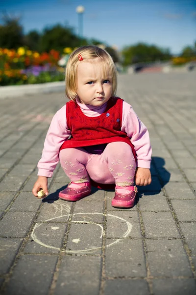 Menina irritada desenha sorriso no asfalto — Fotografia de Stock
