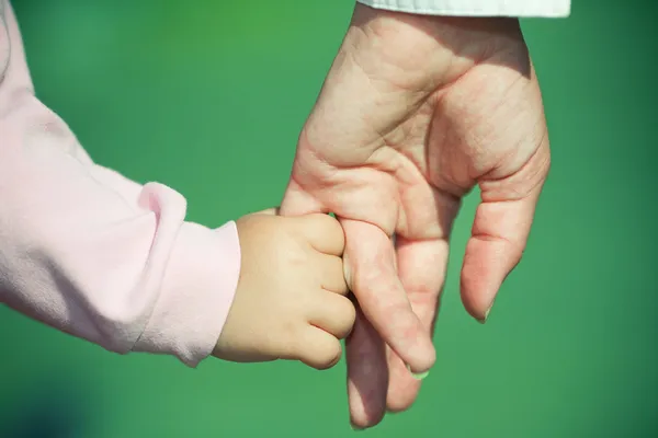 Flicka håller mamman för hand — Stockfoto