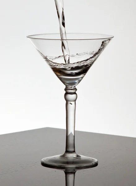 L'eau coulant dans un verre Martini — Photo