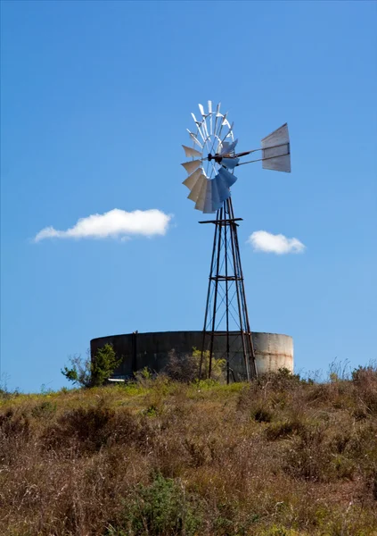 Molino de viento de metal y presa en una colina —  Fotos de Stock