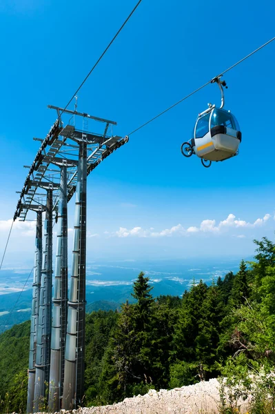 Mountain bike on cable car elevator over alpine forest — Stock Photo, Image