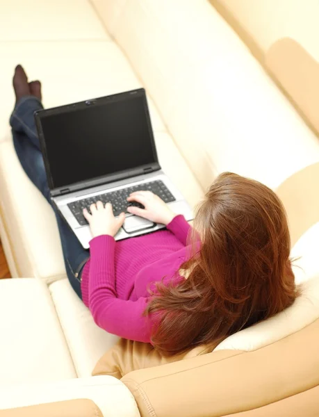 Bir dizüstü bilgisayarda çalışan güzel bir genç kadın — Stok fotoğraf