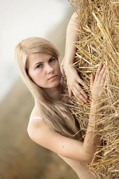 Junge sexy Frau unter dem Stroh. — Stockfoto