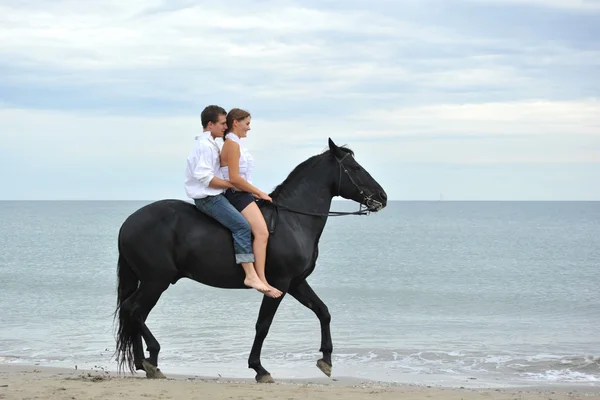 Para i konia na plaży — Zdjęcie stockowe