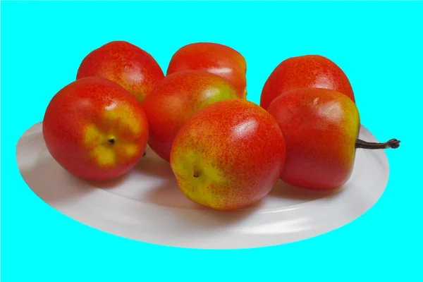 Czerwone małe jabłka są na białym talerzu — Zdjęcie stockowe