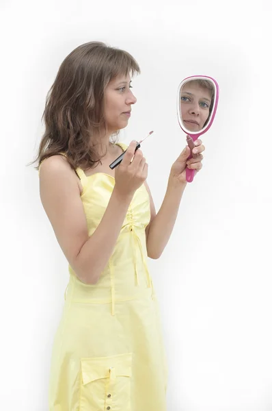Die junge Frau blickt in den Spiegel — Stockfoto