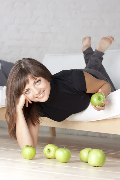Menina sorridente bonita com maçãs verdes — Fotografia de Stock