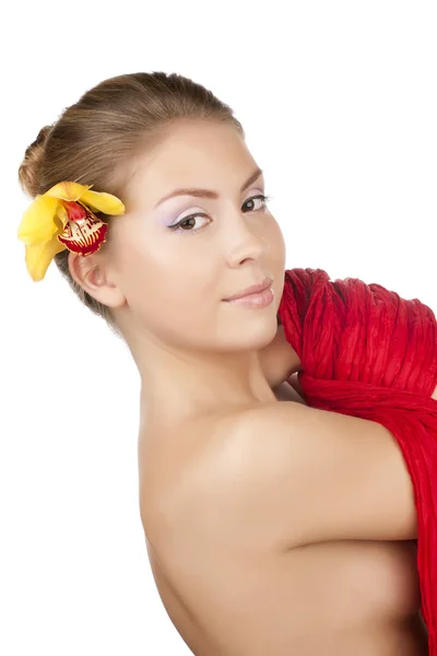 Mooi meisje in rood met een gele orchidee — Stockfoto