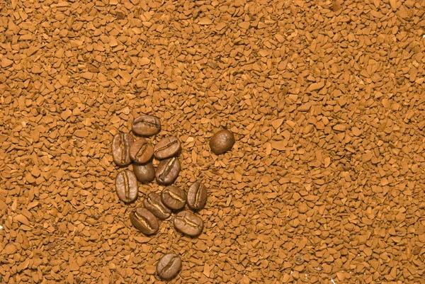 Granos de café en fondo de café instantáneo —  Fotos de Stock