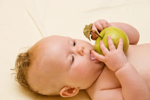 Ребенок облизывает яблоко — стоковое фото
