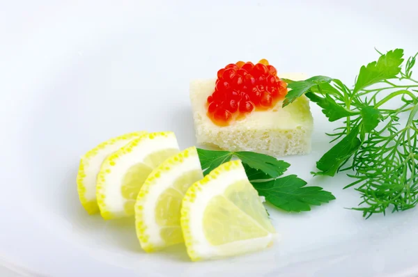 Kırmızı havyar ve beyaz tabakta yeşillikleri ile sandviçler — Stok fotoğraf