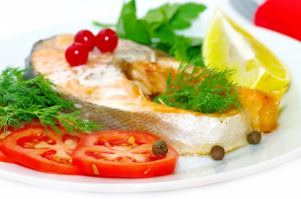Жареная рыба с овощами и ломтиком лимона — стоковое фото