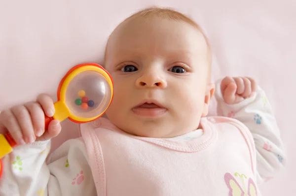 Baby girl holding rattle — Stock Photo, Image