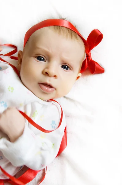 Menina bebê com fita vermelha — Fotografia de Stock