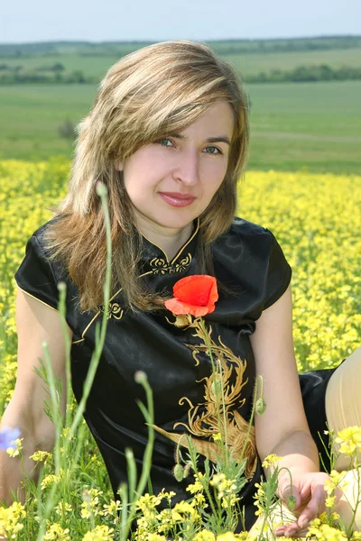สาวสวยในทุ่งดอกไม้สีเหลือง — ภาพถ่ายสต็อก