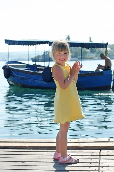Menina na praia no fundo do barco — Fotografia de Stock