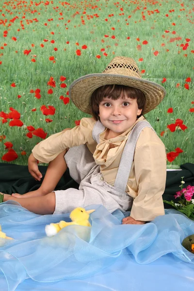 Un chico con atuendo rural en el campo de flores —  Fotos de Stock