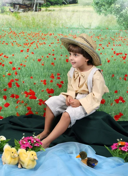 Мальчик в сельской одежде на цветочном поле — стоковое фото