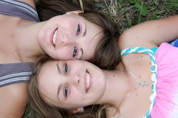 Dwie dziewczyny, leżąc na trawie i patrzeć w niebo — Zdjęcie stockowe