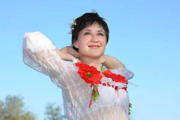 Beautiful girl in national costume on a background of blue sky — Stock Photo, Image