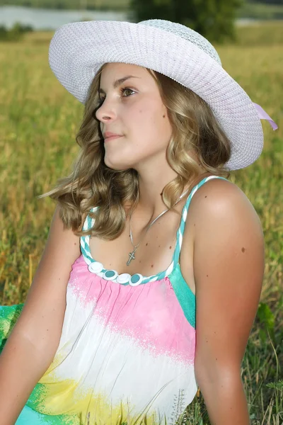 Mooi meisje in de witte hoed op het gebied — Stockfoto