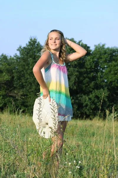 Gyönyörű lány a kezében a mező kalapot — Stock Fotó