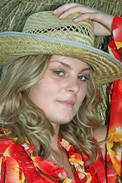 Blondýna v slaměný klobouk proti kupce sena — Stock fotografie