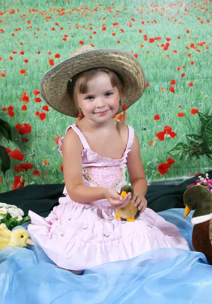 Piękna dziewczyna w słomkowym kapeluszu karmione kaczka — Zdjęcie stockowe