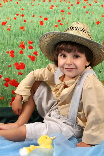 A fiú a vidéki öltözékben, a virág mező: — Stock Fotó