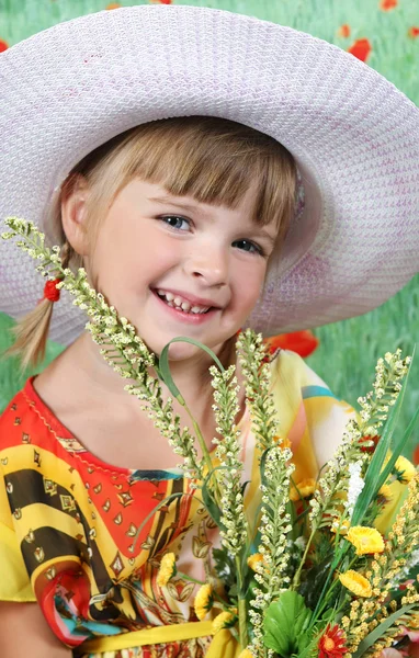Mooi meisje in een hoed met wilde bloemen — Stockfoto