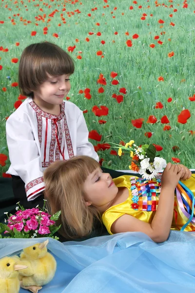 Dívka a chlapec v kroji na pozadí zeleně — Stock fotografie