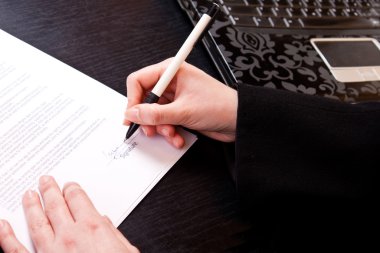 Close-up of signing papers clipart