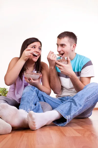 Young couple eating on the floor — Stock Photo, Image