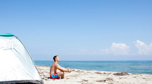 Людина медитує на пляжі — стокове фото