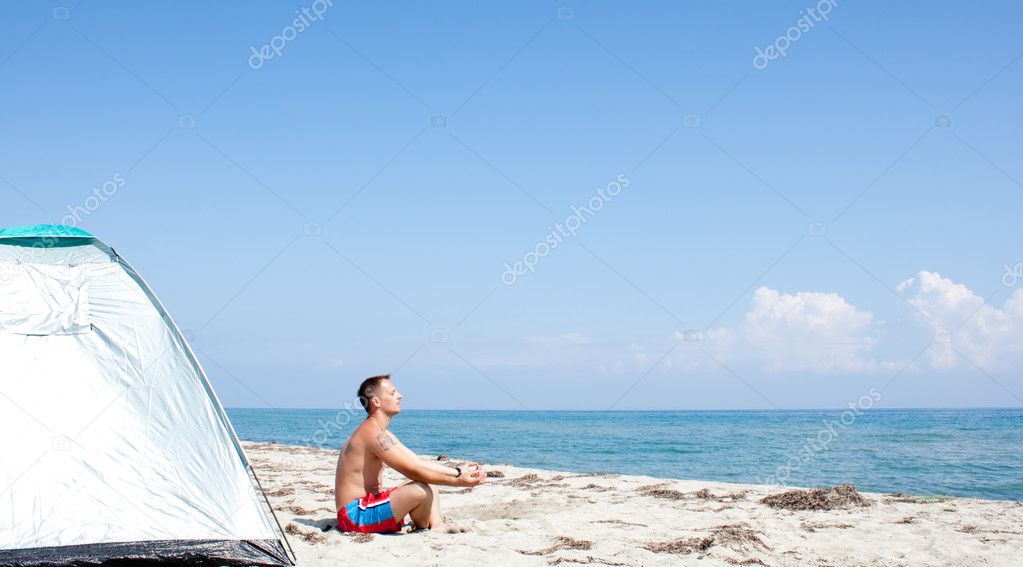 Man meditating on beach