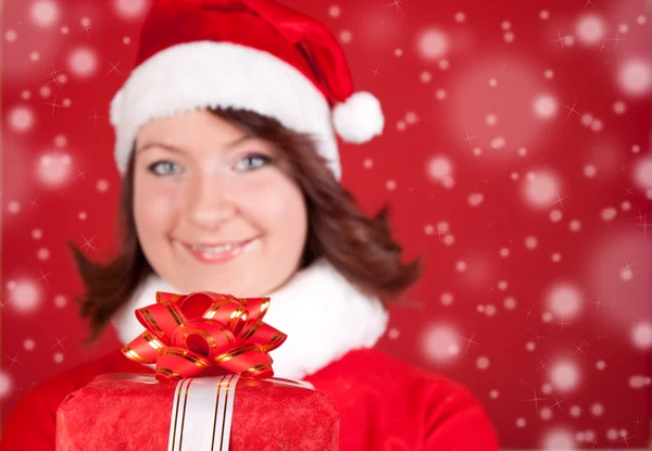 Усміхнена дівчина Санта тримає подарунок — стокове фото