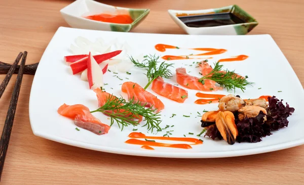Шматочки смачного лосося прикрашені соусом спеціями та морепродуктами — стокове фото