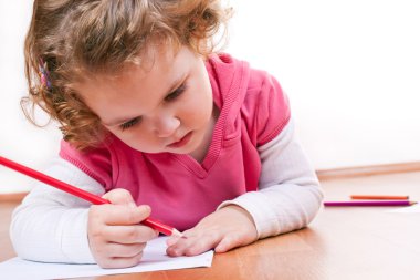 Llittle girl drawing around her hand clipart