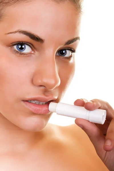 Retrato de una mujer que aplica brillo labial — Foto de Stock