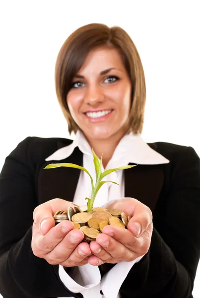 Mujer sosteniendo una planta creciente y monedas — Stockfoto