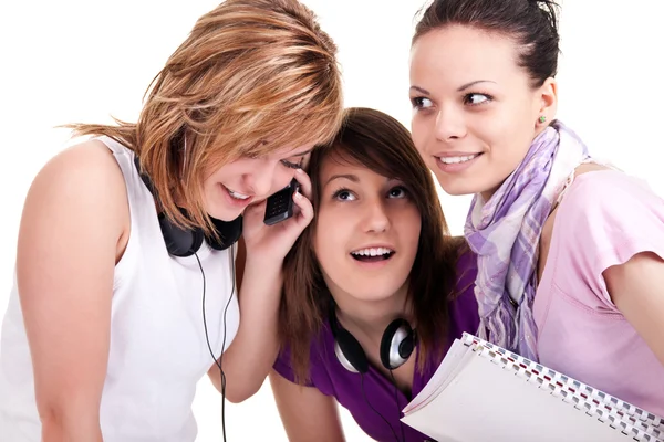 Девушки с любопытством слушают мобильный — стоковое фото